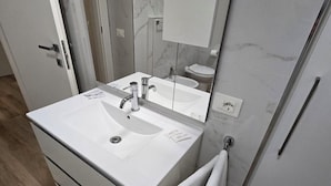 A modern bathroom with a white sink, mirror, and towel rack. - DANITO ROOMS 3 (Ancona)