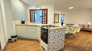 Une cuisine de taille réduite comprenant une cuisinière, un évier et un coin repas.