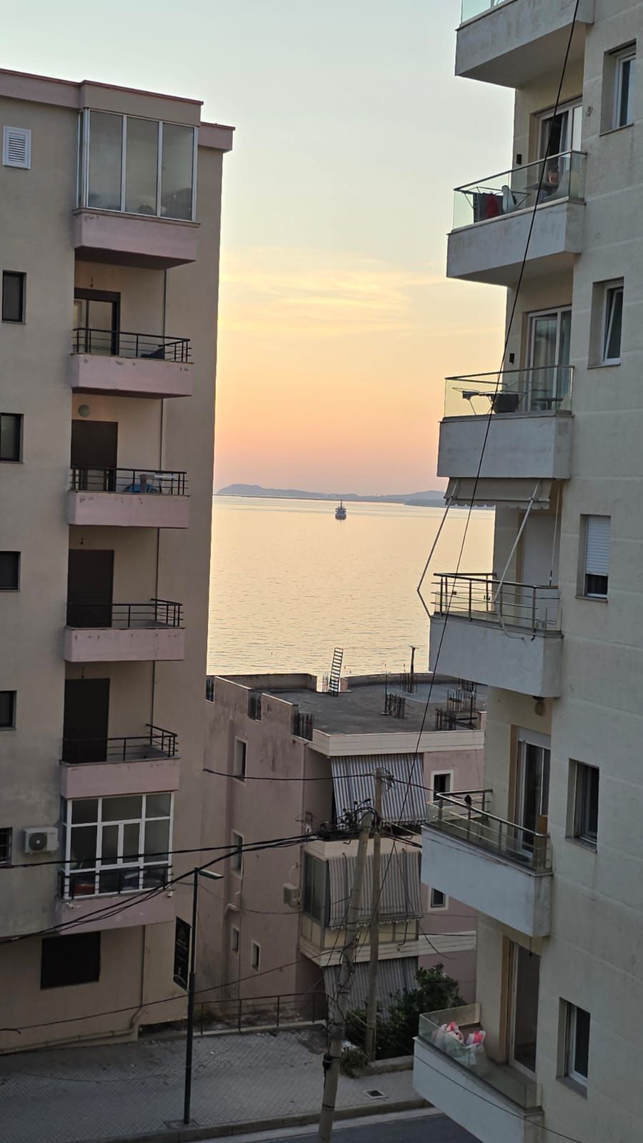 A view of a residential building with multiple balconies overlooking a body of water.