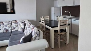 A modern living room with a sofa and a dining table with chairs. - Tirent Apartment - Your Beach Home in Vlorë (Vlore)