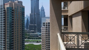 Un immeuble de grande hauteur, avec une tour imposante en arrière-plan, qui est probablement un hôtel ou un immeuble de bureaux doté de nombreux étages et de balcons.