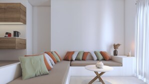 A modern living room with a sectional sofa, a round coffee table, and a built-in shelf. - 2-bedroom Villa Penelope (Antiparos)