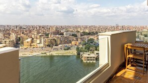 Un balcon offrant une vue sur une rivière et sur une ville aux bâtiments très rapprochés.