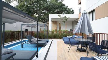 Utomhuspool, parasoller och solstolar