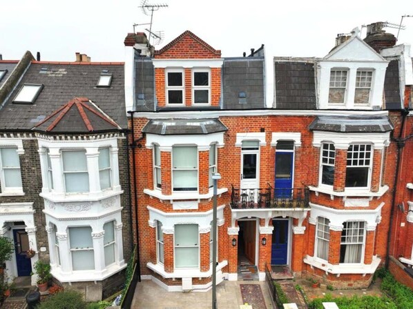 A row of terraced houses with bay windows and a central entrance. - PS5+Games+Parking|Sleeps 6, 60"TV + Netflix, ideal for Business/Relocator stays (London)