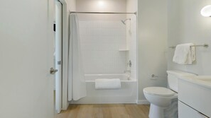 A modern bathroom with a shower, toilet, and sink.