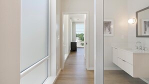 A modern bathroom with a large mirror, a sink, and a toilet.