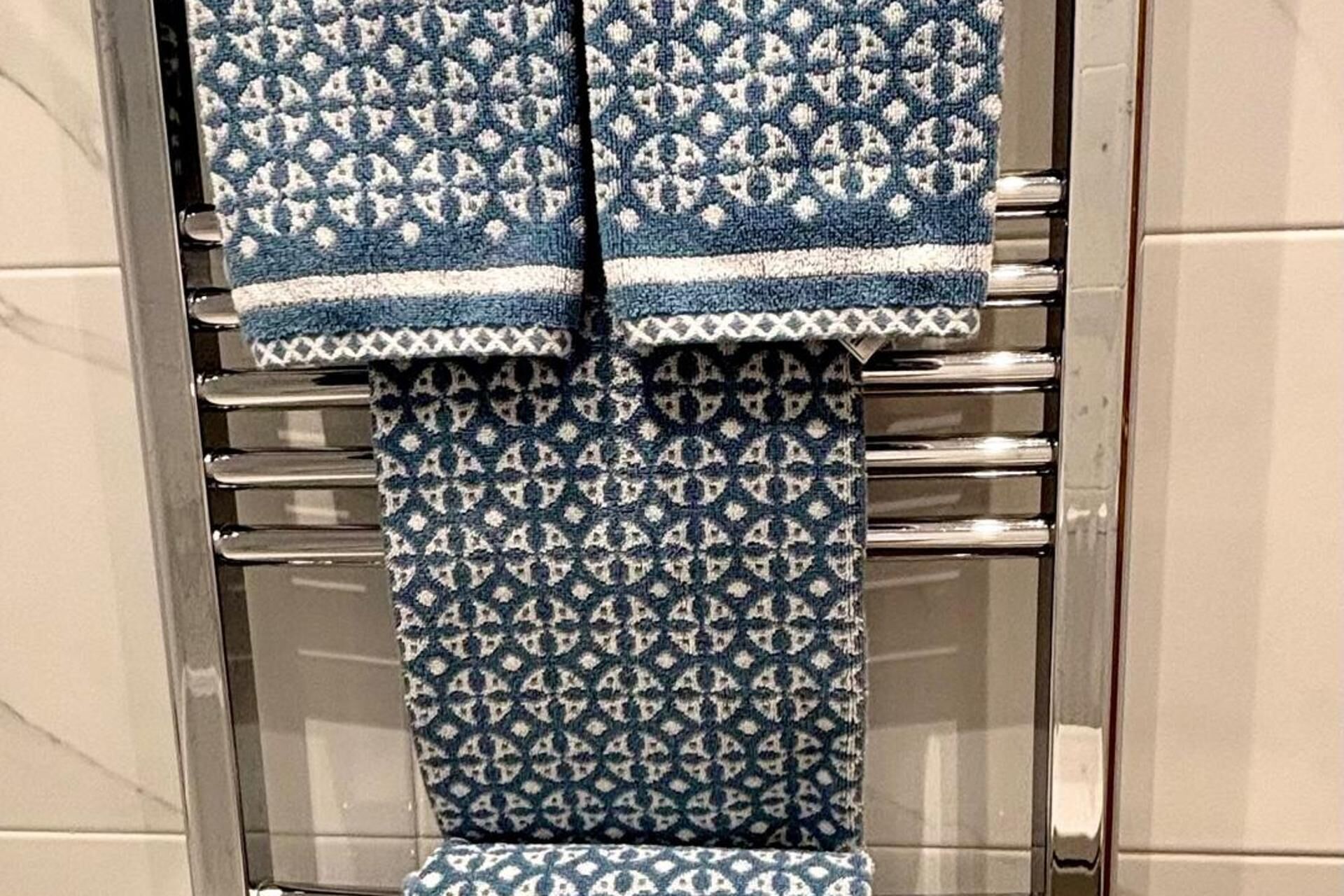Une salle de bain avec un porte-serviettes sur lequel sont posées deux serviettes.