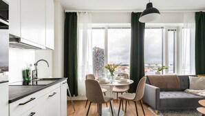 Eine moderne Wohnung mit Küche, Essbereich und Wohnzimmer, mit Blick auf die Stadt.