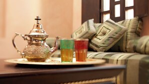 A traditional tea set with a teapot and glasses on a tray, placed on a table in a room with a sofa and pillows in the background. - Hapimag Resort Marrakesh (Marrakech)