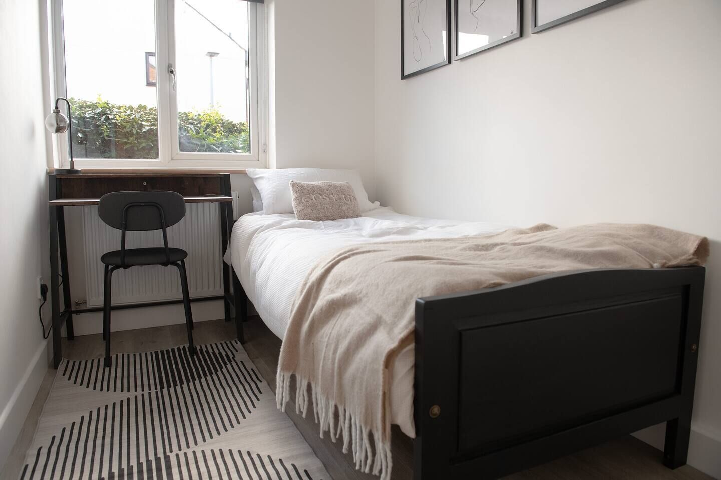 Une chambre avec un lit simple, une chaise, un radiateur et une fenêtre.
