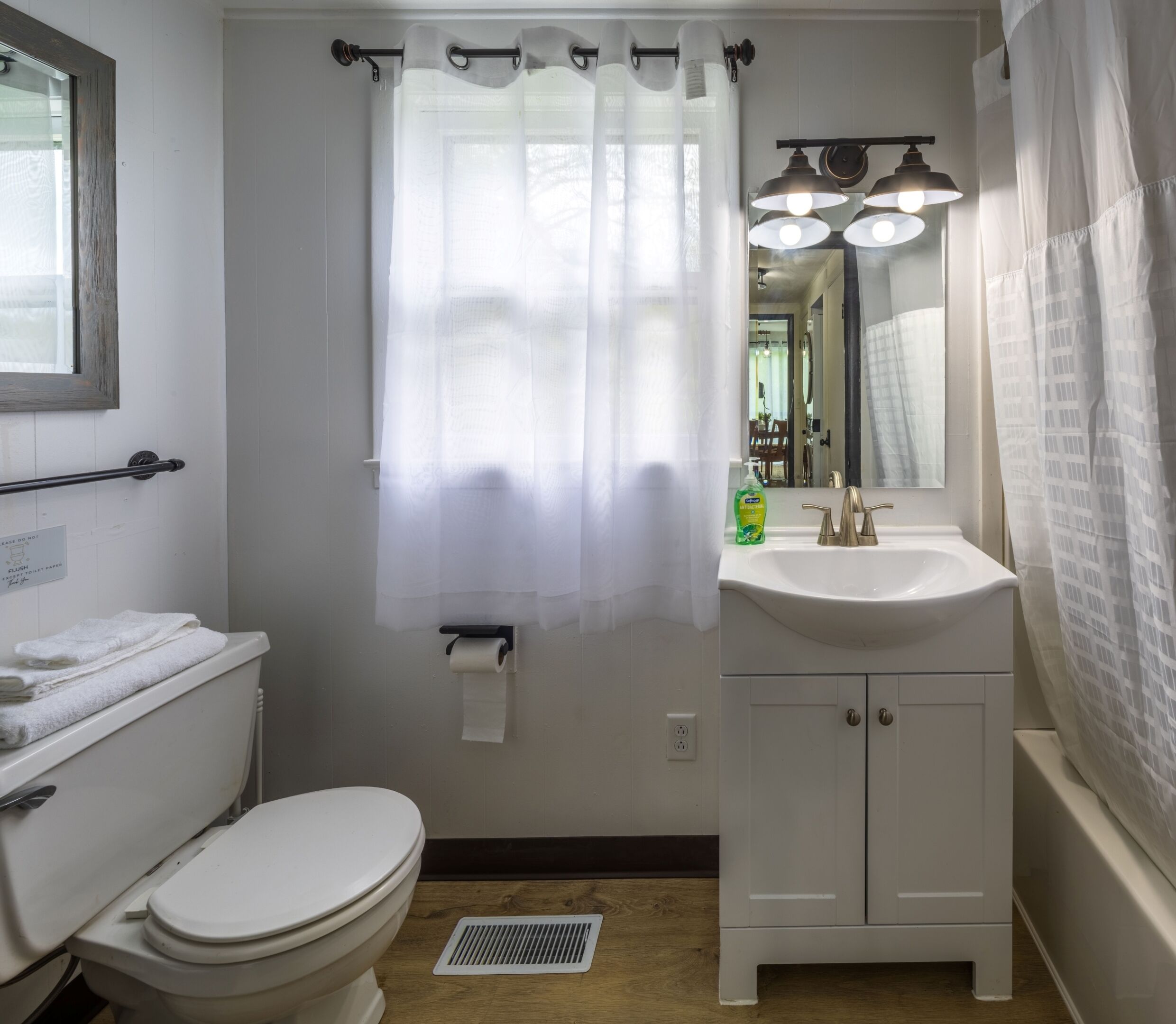 Een badkamer met toilet, wastafel en douchegordijn.