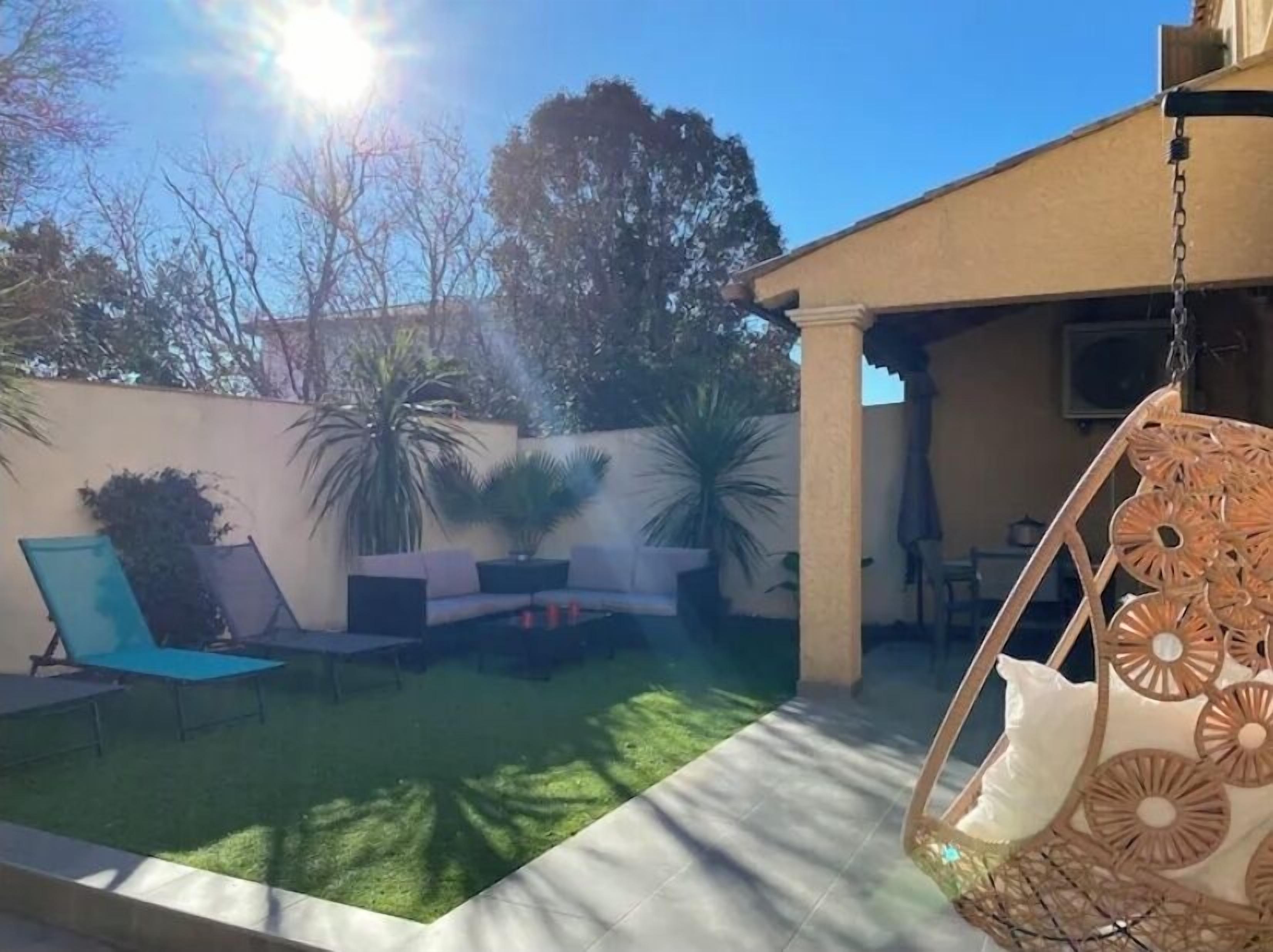 Ein Garten mit Terrasse, Gartenmöbeln und einer Hängematte.