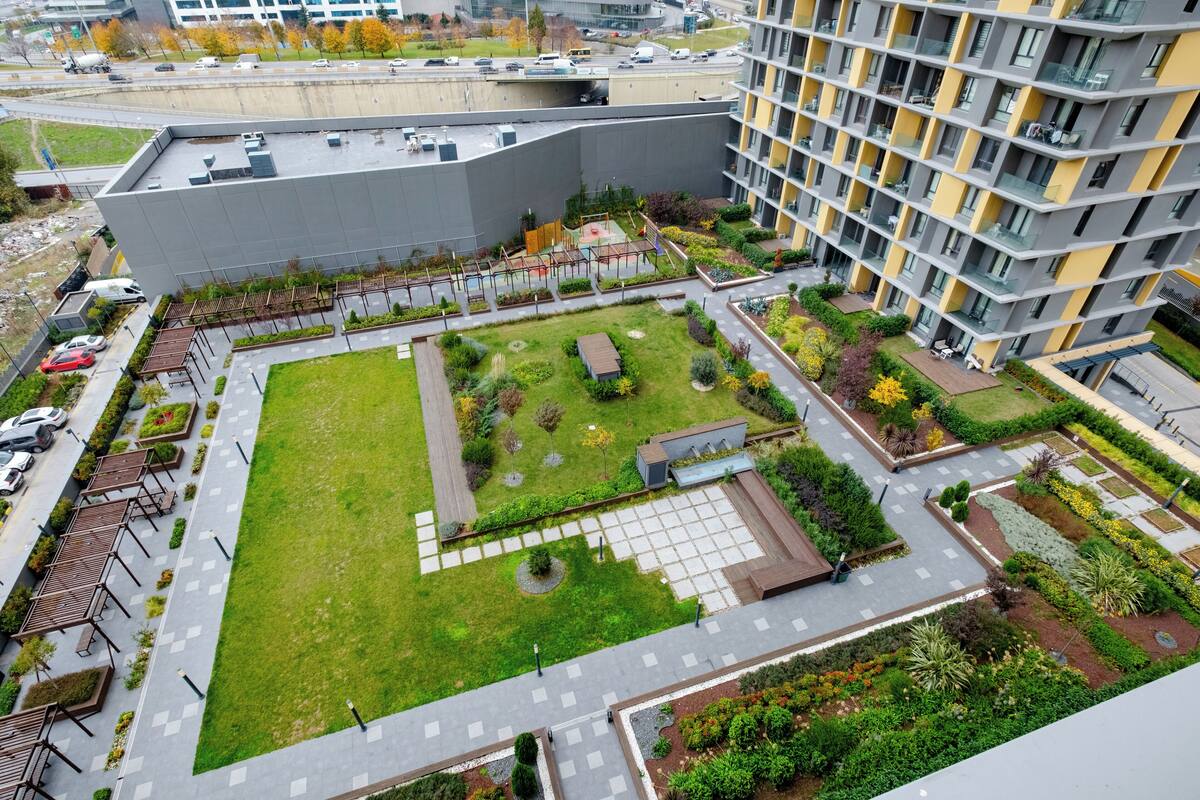 An aerial view of a modern building complex with a central courtyard, surrounded by residential units with balconies.