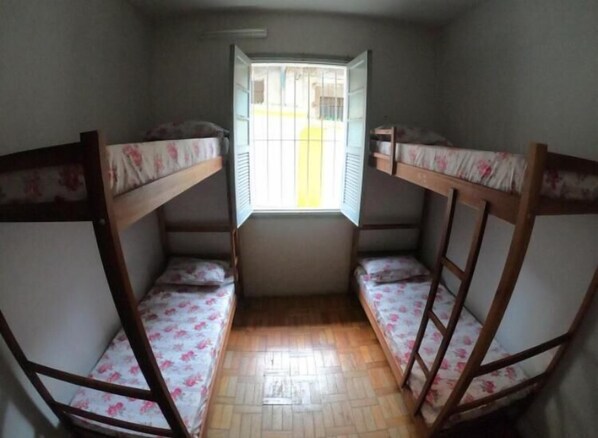Ein Zimmer mit Etagenbetten und einem vergitterten Fenster.