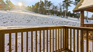 A wooden deck with a snow-covered slope in the background. - Cozy Lake Region Townhome – Steps from Moose Pond in Bridgton (Bridgton)