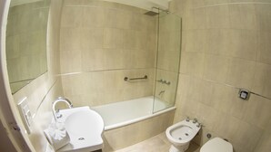 Un baño con bañera, lavamanos, bidé e inodoro.