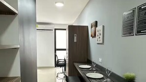 Una cocina moderna con una encimera amplia, taburetes de bar y una planta en maceta.