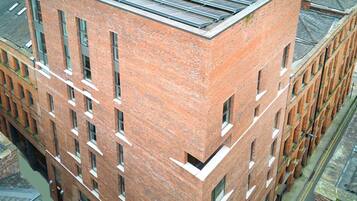 A multi-story brick building with a flat roof, large windows, and a corner entrance.