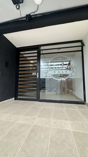 Entrada de hotel con puerta de cristal y puerta corredera de cristal.