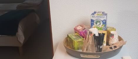 Eine kleine Küchenzeile mit einem weißen Kühlschrank, einer Speisenplatte und einer dekorativen Deckenleuchte.
