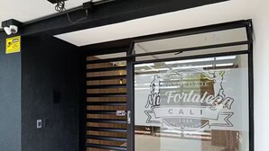 Entrada de hotel con puerta de cristal mostrando 'Mi Fortaleza Cali 2024'.