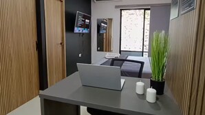 Un espacio de oficina moderno con un escritorio, una computadora portátil y una planta en maceta.