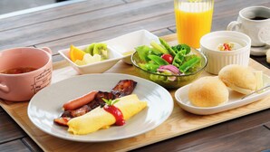 A breakfast tray with eggs, bacon, sausage, toast, fruit, and a salad. - CS RESORT (Miyakejima)
