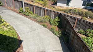A curved concrete pathway bordered by a wooden fence and greenery. - Workspace near Microsoft, Meta, Lumen Field and T-Mobile Park (Bellevue)
