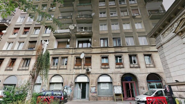 A multi-story building with arched windows and balconies.