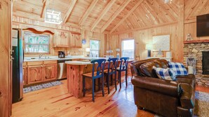 L’intérieur d’une cabane en bois comprend une cuisine, un coin repas et un salon.