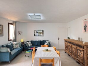 A living room with a sofa, a dining table, and a cabinet.