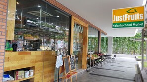 A storefront with a sign reading "JustFruits Neighborhood Market". - The Robertson Residence KL (Kuala Lumpur)
