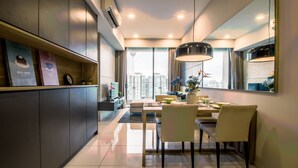 A modern dining area with a large window, a dining table, chairs, and a pendant light.