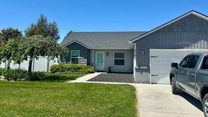 Una casa residencial con garaje, entrada para vehículos y césped.