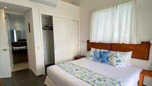 Une chambre spacieuse avec un grand lit, un ventilateur de plafond et une vue sur la salle de bain.