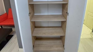 A walk-in closet with multiple shelves and a sliding door.