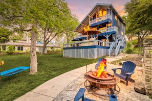 A two-story house with a deck, a fire pit, and outdoor seating. - Blue Heron's Nest - Waterfront, Sauna, Kayaks, Tubes (New Braunfels)