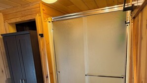 Un interior de fusta amb una porta corredissa de vidre, un armari fosc i una catifa amb disseny.