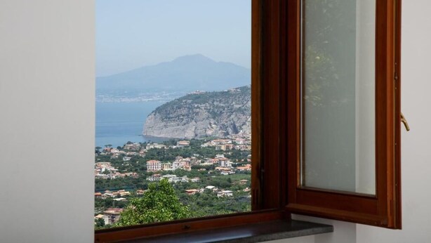A window with a view of a coastal town, a mountain, and the sea. - L' ARANCIO IN FIORE (Sant'Agnello)