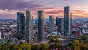 A cityscape with modern high-rise buildings, a mix of commercial and residential structures, and a clear sky. - Manchester Oasis - Modern 3 Bedroom Apartment (Manchester)