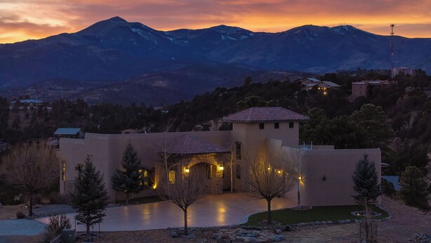 A modern house with a spacious patio, surrounded by a mountainous landscape. - Experience Ruidoso from the top, 360 views,private pickleball, hot tub (Ruidoso)