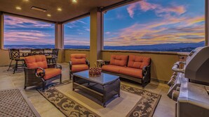A spacious balcony with wicker furniture, a grill, and a view of the sky and landscape. - Experience Ruidoso from the top, 360 views,private pickleball, hot tub (Ruidoso)