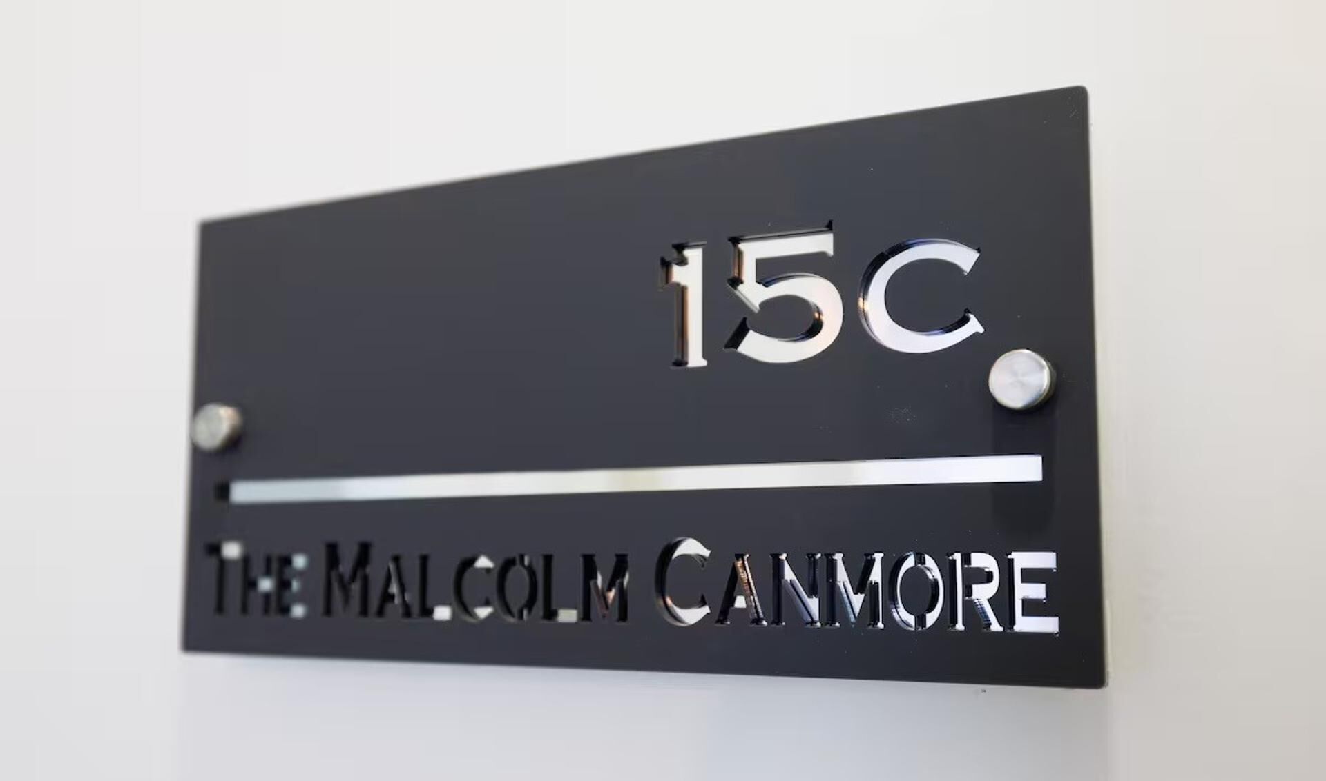 A black sign with "15C" and "THE MALCOLM CANMORE" on it.