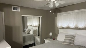 A bedroom with a bed, nightstands, a mirror, and a ceiling fan. - Spacious 2-bedroom condo with AC, WiFi in beautiful Osage Beach (Osage Beach)