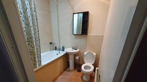 A small bathroom with a bathtub, sink, and toilet. - Bradford 2-bedroom Home - Sleeps 4 - Free Parking (Bradford)