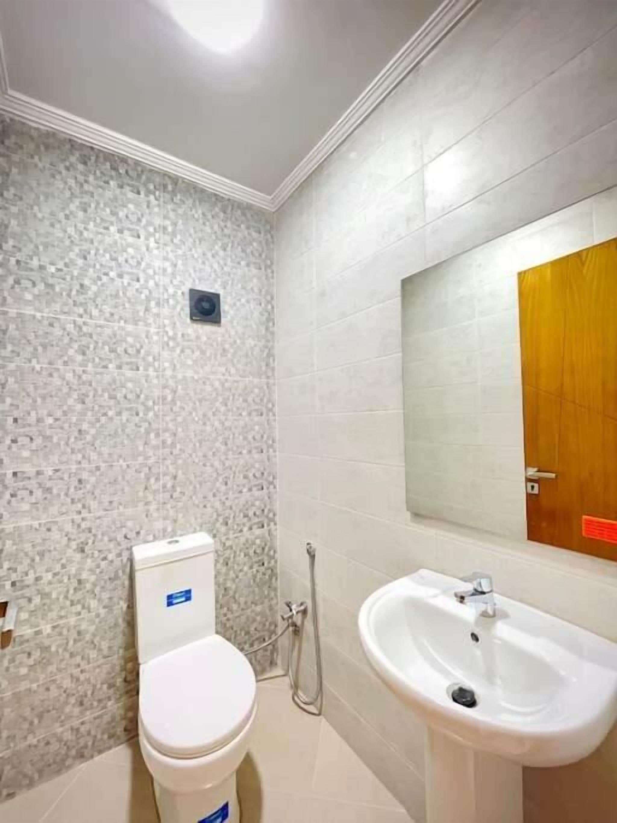 Un baño con inodoro, lavabo y ducha.