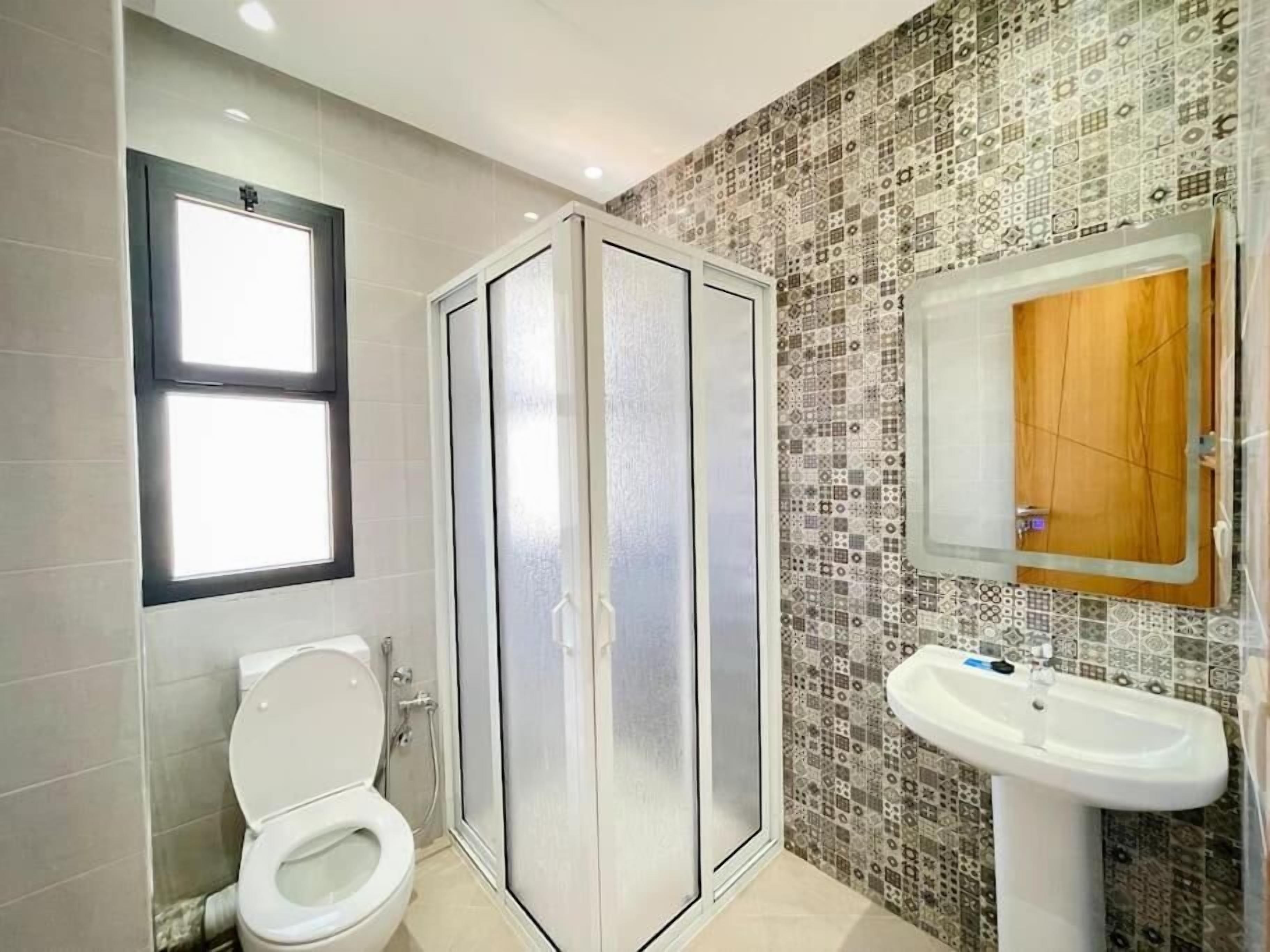 Un bagno con il water, uno spazio doccia e un lavandino.