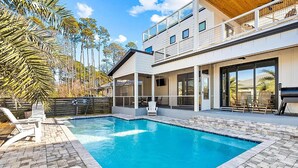 A modern house with a swimming pool, large windows, and a balcony. - Talulah Sunrise (Panama City Beach)