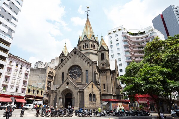 A historic church with a prominent spire and large stained glass window.